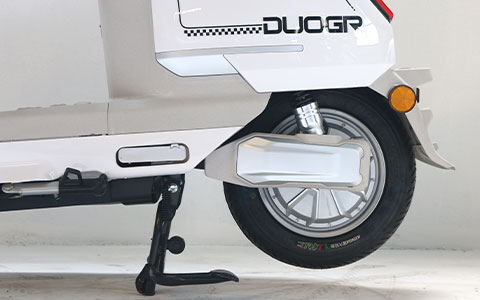 Electric Scooter | Rear Wheel & Shock Absorption Detail Rear wheel with shock absorption and tubeless tire for white electric motorcycle, stable on uneven roads