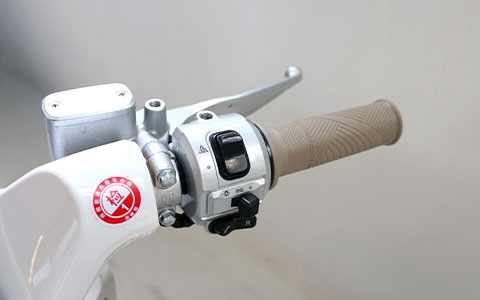 Electric Scooter | Anti-Slip Handlebar Control Detail Anti-slip handlebar with waterproof control switches for white electric scooter, fully functional operation
